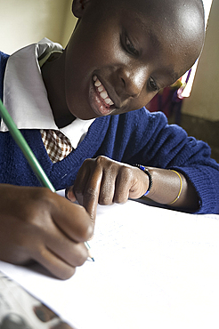 Schoolgirl working happily at school, pupil at Murindati Primary School, Rift Valley, Kenya, East Africa, Africa