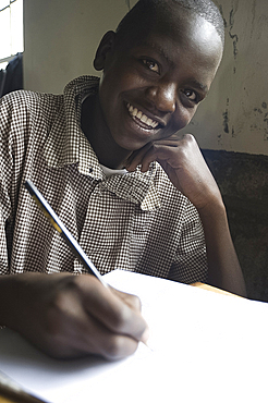 Schoolboy working happily at school, pupil at Murindati Primary School, Rift Valley, Kenya, East Africa, Africa