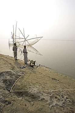 Fisherman and his wife at the rivers edge with nets, Brahmaputra River, Assam, India, Asia