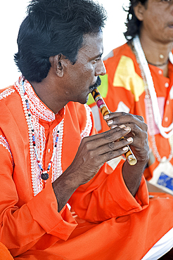 Hindu musician dressed in orange clothing playing ten scale Indian harmonium keyboard, West Bengal, India, Asia