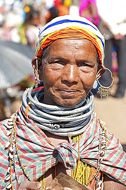 Smiling Bonda tribeswoman wearing cotton shawl over traditional bead costume, beaded cap, large earrings and metal necklaces, Rayagader, Orissa, India, Asia