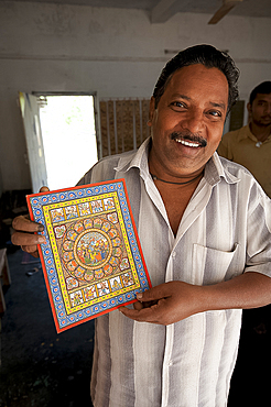 Raghurajpur artist holding up his detailed Orissa style painting depicting Hindu gods and patterns, Raghurajpur, Orissa, India, Asia