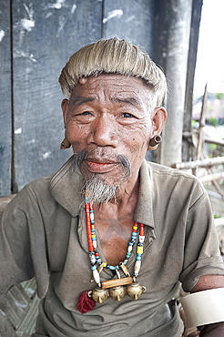 Naga Konyak tribal head hunter with traditional headhunter necklace with brass heads, bamboo earrings, elephant tusk armbands, Ngangting, Nagaland, India, Asia