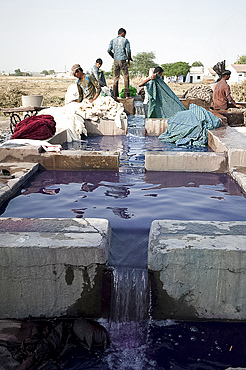 Men washing the starch or dye out of cotton cloth in running water, before drying ready for indigo dyeing, Bhuj district, Gujarat, India, Asia