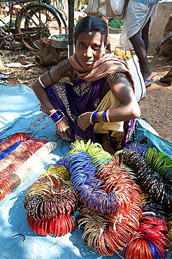 Young woman with ropes of coloured bangles for sale in Mali weekly tribal market, Guneipada, Koraput district, Orissa (Odisha), India, Asia