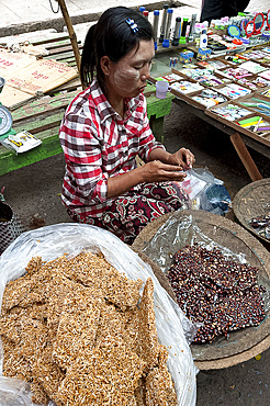 Woman selling delicious home made fresh peanut brittle and vermicelli brittle in Kalaw market, Shan state, Myanmar (Burma), Asia