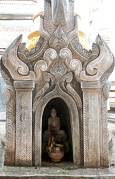 Buddha statue and water pot left by Buddhist devotee inside shrine at the Nyaung Oak monastery, Indein, Inle Lake, Shan state, Myanmar (Burma), Asia