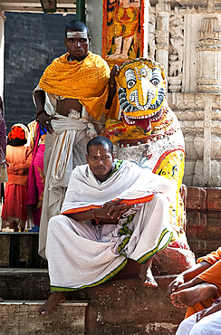 Hindu pilgrims in saffron and white robes, at the gate into Kapilash Temple (Chandrashekhar Temple), Dhenkanal District, Odisha, India, Asia