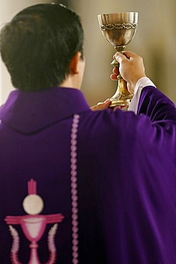 Priest wearing purple roman chasuble, Catholic Mass, Eucharist celebration, Elevation, Quy Nhon, Vietnam, Indochina, Southeast Asia, Asia