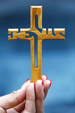 Woman holding a wooden Christian cross with the name of Jesus, symbol of religion and faith, Vietnam, Indochina, Southeast Asia, Asia