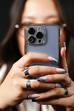 Female hand with smartphones close up, young woman using mobile phone, Instagram, Tik Tok and Facebook, France, Europe