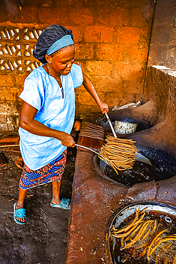 Woman frying klui klui peanuts sticks in a workshop in central Benin