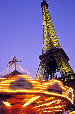 The Eiffel Tower illuminated at night with a carousel spinning, Paris, France, Europe