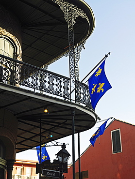 French Quarter building with wrought iron balconies and fleurs de lys flags, New Orleans, Louisiana, United States of America, North America