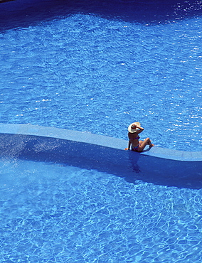 Woman sitting at pool, Cancun, Mexico, North America