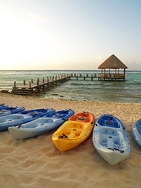 Kayaks on the beach and pier with palapa jutting out into the water from the beach, Mayan Riviera, Akumal, Yucatan, Quintana Roo, Mexico, North America