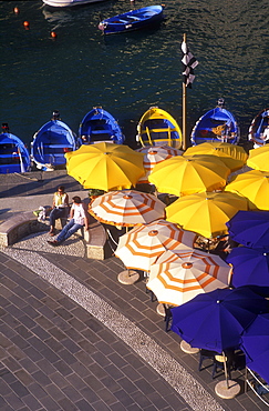 Colorful umbrellas, fishing boats and a couple seated, Vernazza, Cinque Terre, Liguria, Italy, Europe