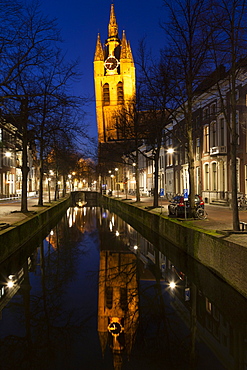 The Oude Kerk's leaning tower (Oude Jan) (Scheve Jan) reflected at night in the Oude Delft canal in Delft, South Holland, The Netherlands, Europe