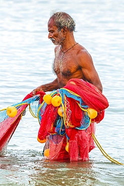 Fisherman retrieving large net to shore at popular Marari Beach, Mararikulam, Alappuzha (Alleppey), Kerala, India, Asia