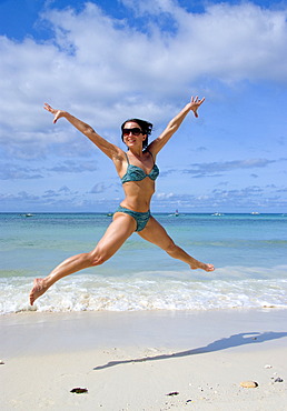 Young woman jumping on the beach