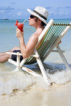 Man with cocktail at seashore