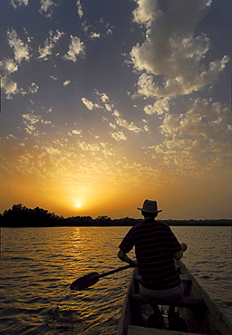 Tourist canoing on the River Gambia und enjoying the sunset, near Tumani Tenda, The Gambia, Africa