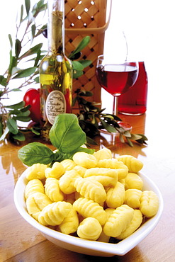 Italian ambiance: gnocchi with basil, red wine, olives and an olive twig