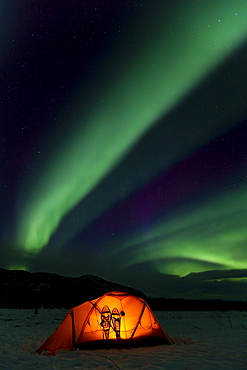 Illuminated expedition tent and traditional wooden snow shoes, Northern Lights, Polar Lights, Aurora Borealis, green, purple, blue, near Whitehorse, Yukon Territory, Canada