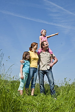 Family standing relaxed in a flower meadow