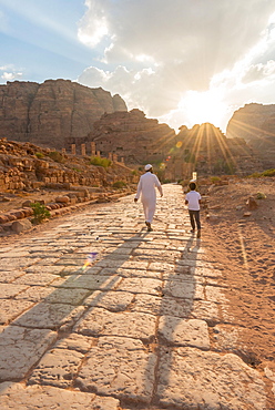 Two locals walk on Old Roman Road next to ruins of Petra, Nabataean city of Petra, near Wadi Musa, Jordan, Asia