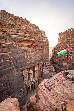 View from above into the gorge Siq, Pharaoh's treasure house carved into rock, facade of the treasure house Al-Khazneh, Khazne Faraun, mausoleum in the Nabataean city Petra with Jordanian flag, near Wadi Musa, Jordan, Asia