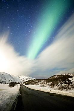 Northern lights over road with snow mountains, near Tromsoe, Troms, Norway, Europe