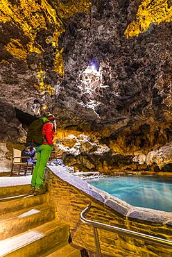 Young woman in a cave with a geothermal spring, Cave and Basin National Historic Site, Banff National Park, Alberta, Canada, North America