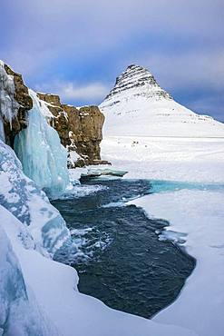 Frozen waterfall Kirkjufellsfoss and the mountain Kirkjufell with snow, peninsula Snaefellsnes, Vesturland, Iceland, Europe