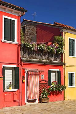 Red house facade decorated with flowers, Burano Island, Venice, Veneto, Italy, Europe