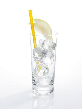 Glass prepared for cocktails, decorated with pear slice cubes, drinking straw, ice cubes, Germany, Europe