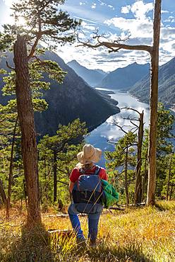 Young hiker at the view from Schoenjoechl, Lake Plansee surrounded by mountains, Tyrol, Austria, Europe