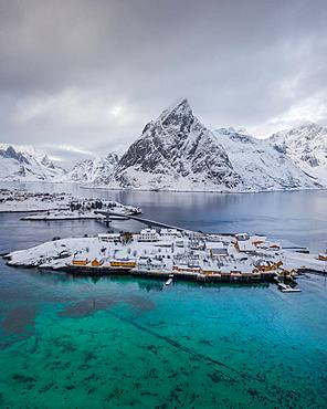 Belbe stilt houses at turquoise sea in winter, Sakrisoy, drone shot, Lofoten, Norway, Europe