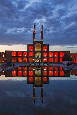 Amir Chaqmaq complex facade illuminated at sunrise and reflecting in a pond, Yzad, Yazd province, Iran, Asia