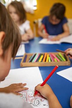 Children painting in kindergarten with crayons, Cologne, North Rhine-Westphalia, Germany, Europe