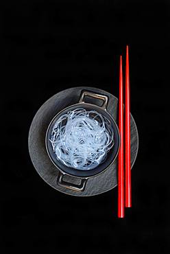 Asian glass noodles in pot and red chopsticks, Germany, Europe