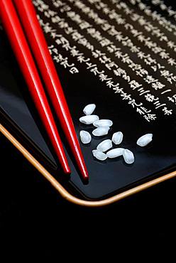 Rice grains and chopsticks on tray, Germany, Europe