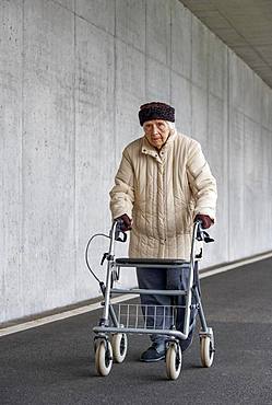 Senior citizen with walker walks in an underpass, Austria, Europe