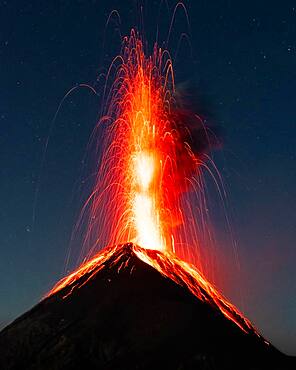 Glowing lava and smoke spitting volcano, volcanic eruption at night, Volcan de Fuego, Guatemala, Central America