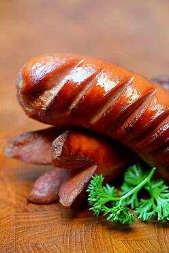 Grilled, sliced sausages on wooden board, Germany, Europe