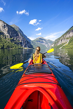 Young woman paddling in a kayak, Geirangerfjord, near Geiranger, Norway, Europe