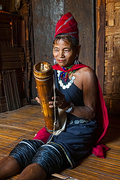 Old Kayah woman playing local instrument, Kayah village, Loikaw area, Kayah state, Myanmar, Asia