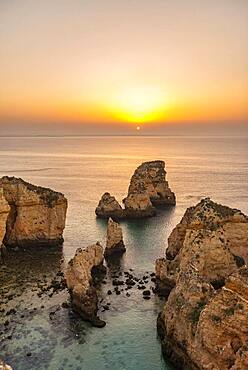 Rugged rocky coast with cliffs of sandstone, rock formations in the sea, Ponta da Piedade, dawn at sunrise, Algarve, Lagos, Portugal, Europe