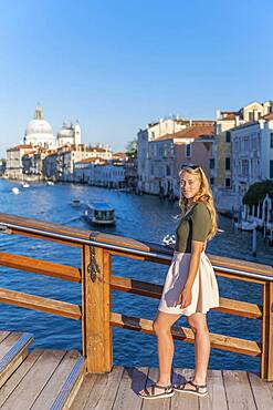 Young woman at the Ponte dell'Accademia, view of the Grand Canal and the Basilica of Santa Maria della Salute, Venice, Veneto, Italy, Europe