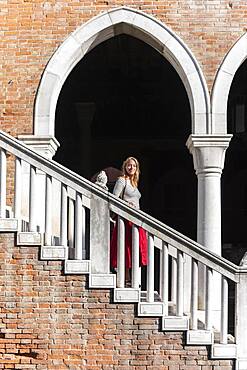 Young woman walking down a staircase, Mercato di Rialto, Venice, Veneto, Italy, Europe